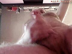 Middelaldrende mann tilfredsstiller ung webkameraviser ved å masturbere på kamera