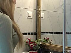 Прсата ситна жена се сагиње да пресвуче доњи веш у купатилу