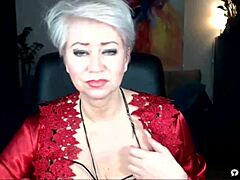 Uma mulher madura russa de lingerie vermelha exibe seus seios nus