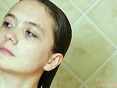 Attraktiv brunettmodell badar i en het dusch