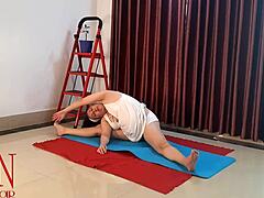 Seorang wanita dalam lingerie putih berlatih yoga di gym