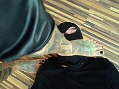 A tetovált MILF dominálja lábszolgáját egy forró mezítlábas videóban
