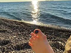 Η κυρία Lara απολαμβάνει την λατρεία των ποδιών και το παιχνίδι με τα δάχτυλα των ποδιών στην παραλία