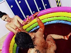Lesbiennes met grote nepborsten genieten van worstelen in een zwembad met gelatine